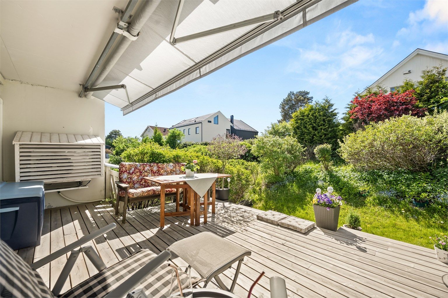 Terrassen er belagt med terrassebord og har markise som gir fleksibel skjerming mot sol og lett regn.