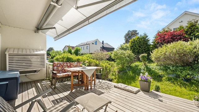 Terrassen er belagt med terrassebord og har markise som gir fleksibel skjerming mot sol og lett regn.