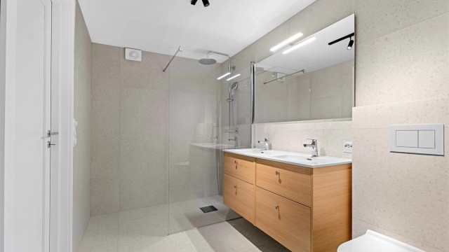 Badet i underetasjen med stor dusj, dobbel servant og baderomsinnredning fra Foss Bad