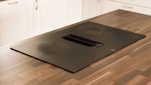 Den integrerte kokeplaten med luftekanal har matt overflate for å matche benkeplaten.