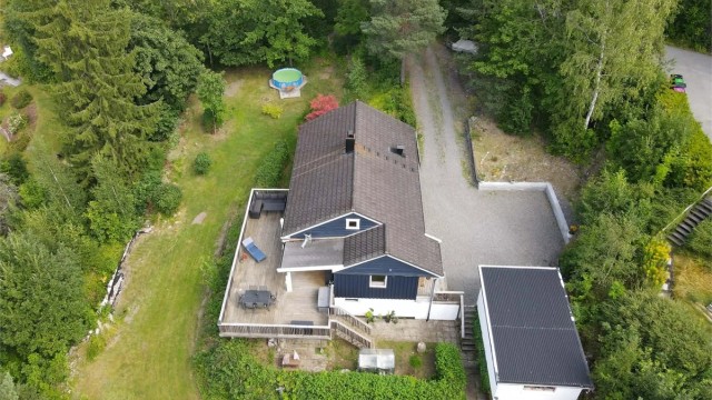 Oversikt over eiendommen med bolighus, garasje og den store tomten. - Del av gårdsplass utenfor tomtegrensen