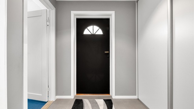 Vindfang med flislagt gulv og skyvedørsgarderobe for yttertøy.