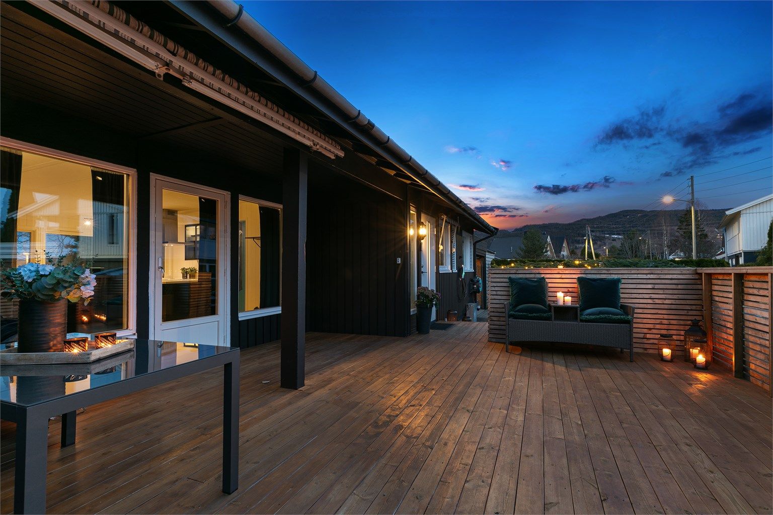 Det er dekke, levegger og rekkverk i tre, og i et overbygg er det montert markise. 