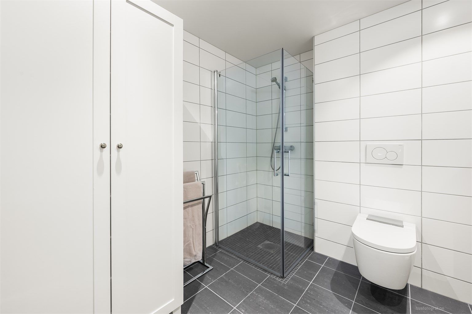 Badet har dusjhjørne med foldedører av glass.