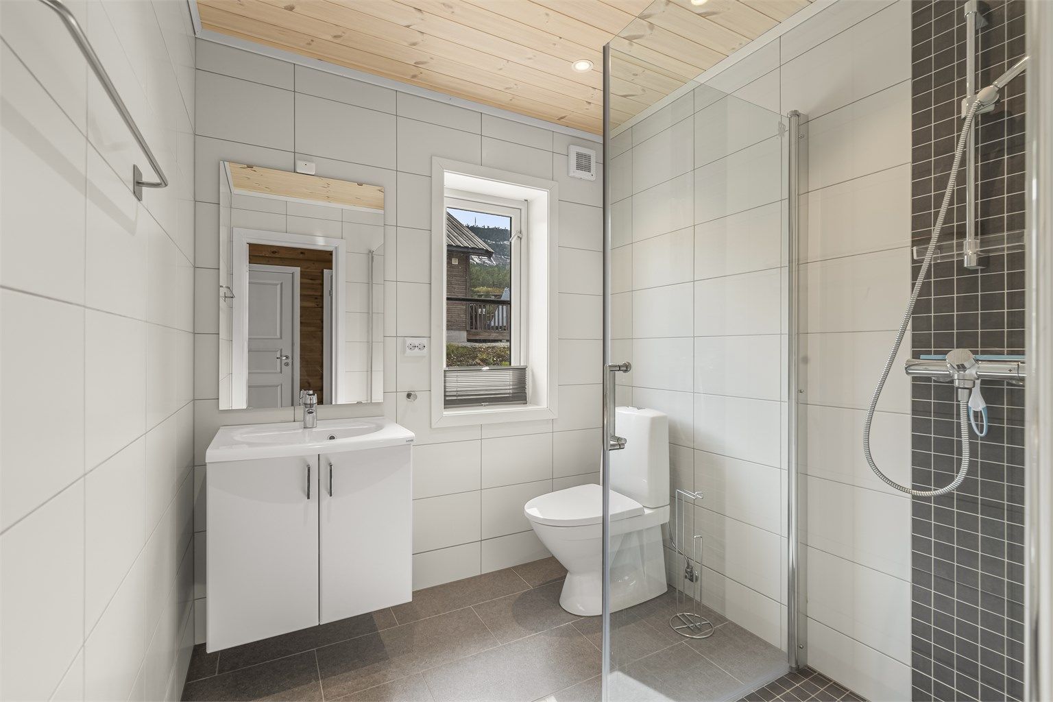 Badet er flislagt med varmekabler og downlights