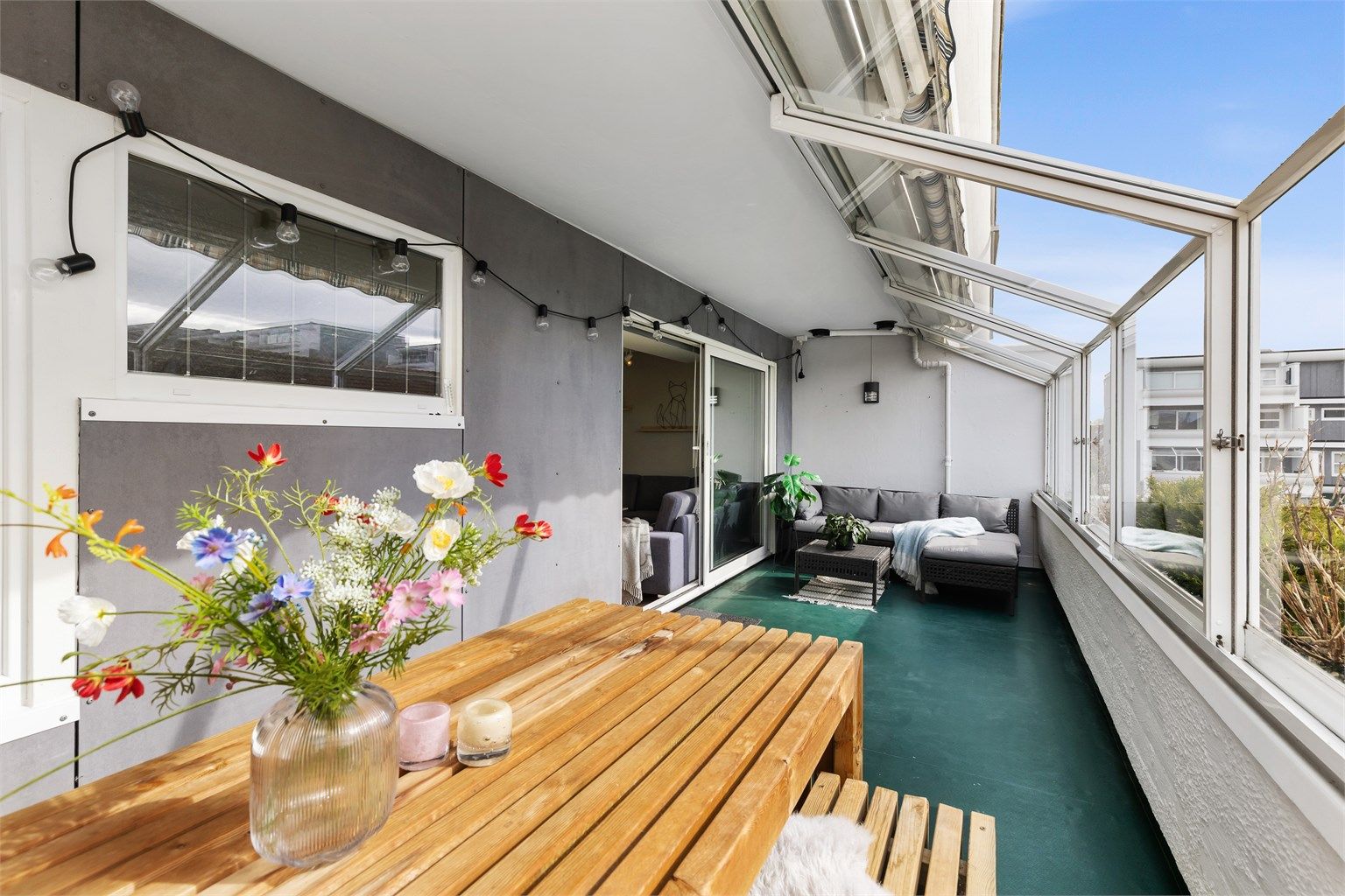 Her er det rikelig med plass for både en sittegruppe og et spisebord. Skyvedørene i glass kan åpnes helt, og gjør balkongen til en åpen uteplass på varme dager.