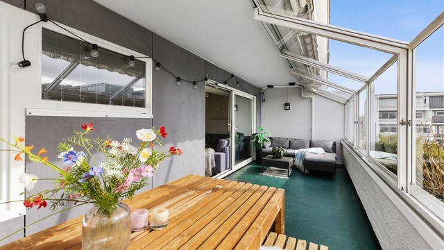 Her er det rikelig med plass for både en sittegruppe og et spisebord. Skyvedørene i glass kan åpnes helt, og gjør balkongen til en åpen uteplass på varme dager.