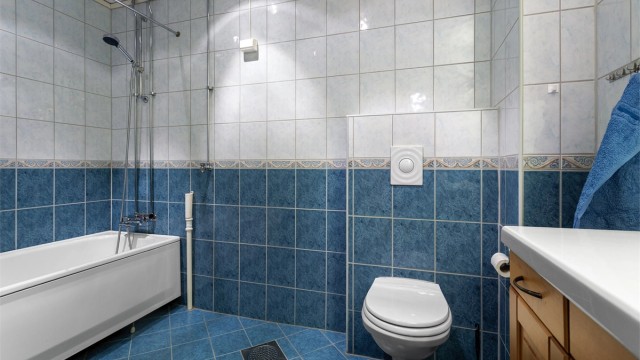 Innredningen består av en servant nedfelt i underskap, vegghengt toalett og badekar.