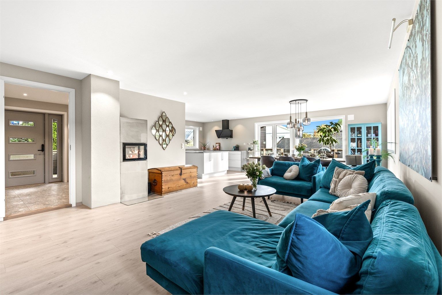 Stuen fremstår som både romslig og elegant, med store vindusflater som slipper inn rikelig med naturlig lys og skaper en behagelig atmosfære gjennom hele dagen. 