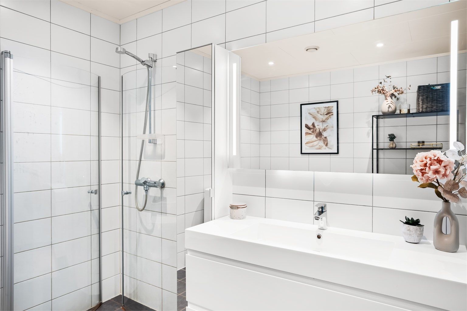 Baderomsinnredning med heldekkende servant og speil med integrert overlys.