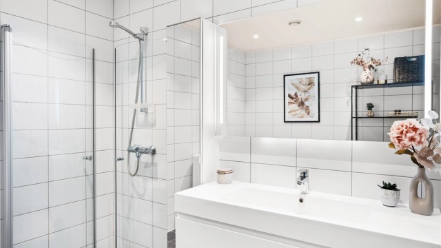 Baderomsinnredning med heldekkende servant og speil med integrert overlys.