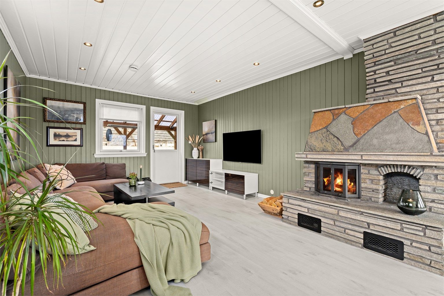 Sofakroken innbyr til hyggelige tv kvelder og om vinteren er det koslig med fyr på peisen, utgang til overbygget uteplass