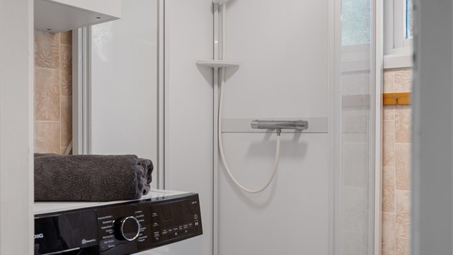 Praktisk dusjhjørne og plass til vaskemaskin på badet.
