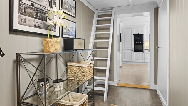 Fra overbygget inngangsparti er det adkomst til romslig entré. Her er det god plass til oppbevaring av sko- og yttertøy i flott skyvedørsgarderobe med speilfronter.