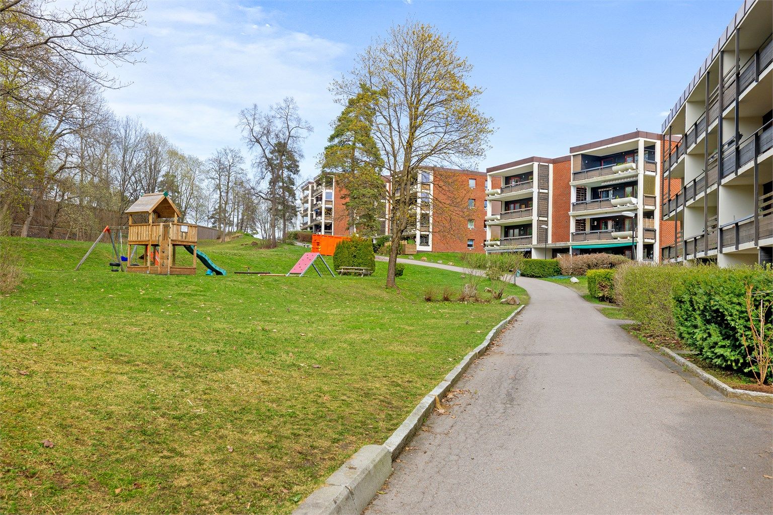 Sameiets felles tomt er pent opparbeidet med plener, beplantning og interne veier.