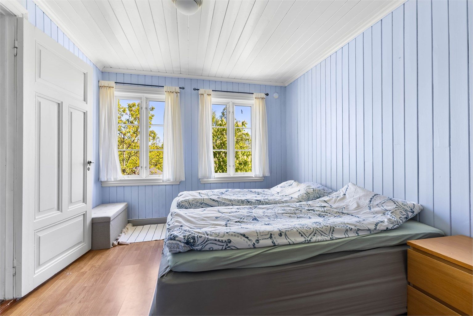 Et av tre soverom i loftsetasjen, med heltre gulv og panel i taket.