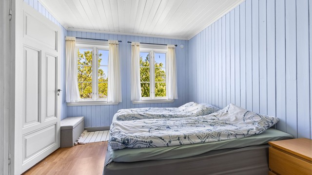 Et av tre soverom i loftsetasjen, med heltre gulv og panel i taket.