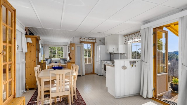 Oppholdsrommet med flere vinduer og utgangsdører med glassfelt gjør stuen og kjøkkenet til et lyst og godt sted å oppholde seg.