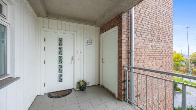 Overbygget inngangsparti med elektronisk kodelås ved svalgangen.