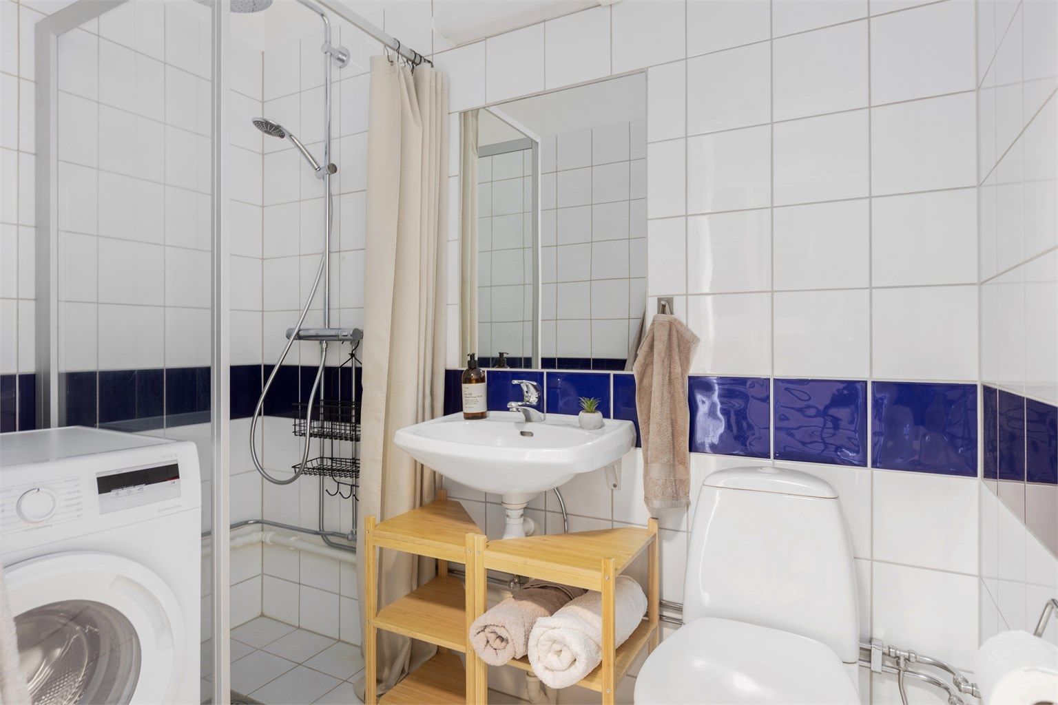 Flislagt bad med gulvvarme og opplegg for vaskemaskin.