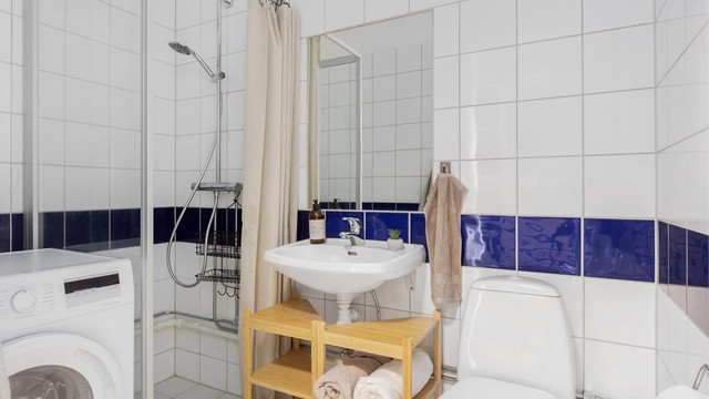 Flislagt bad med gulvvarme og opplegg for vaskemaskin.