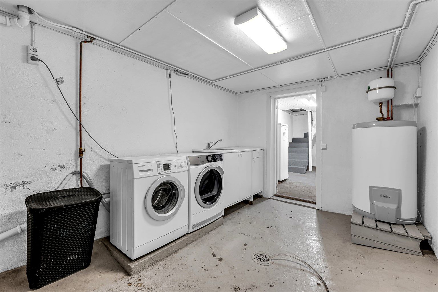 Romslig vaskekjeller som gir god arbeidsplass og effektiv organisering av klesvasken. I kjelleren finner man for øvrig tre praktiske boder – ideelle for oppbevaring av sesongutstyr, verktøy eller annet du vil ha lett tilgjengelig.