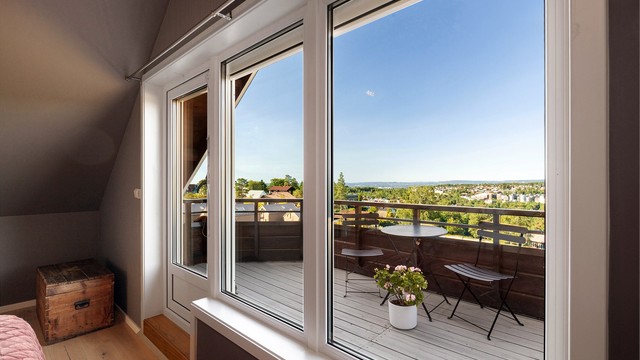 De store vinduene gir soverommet rikelig med dagslys og komplimenterer de lune fargene