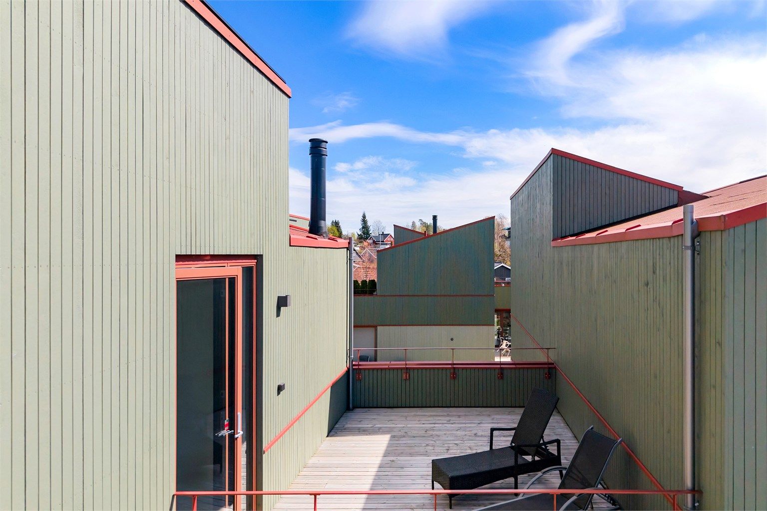 Moderne arkitektur med pulttak og stående trekledning.