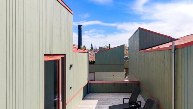 Moderne arkitektur med pulttak og stående trekledning.