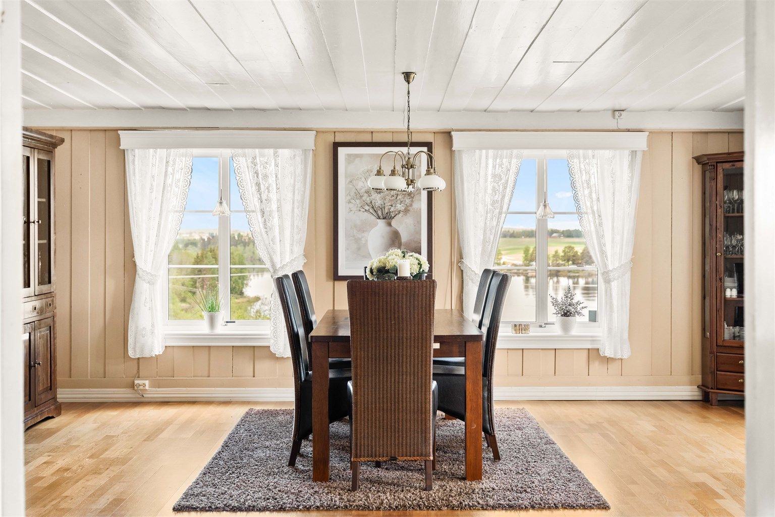 Spisestuen har plass til et stort spisebord og har utsikt mot eiendommens uteområder.