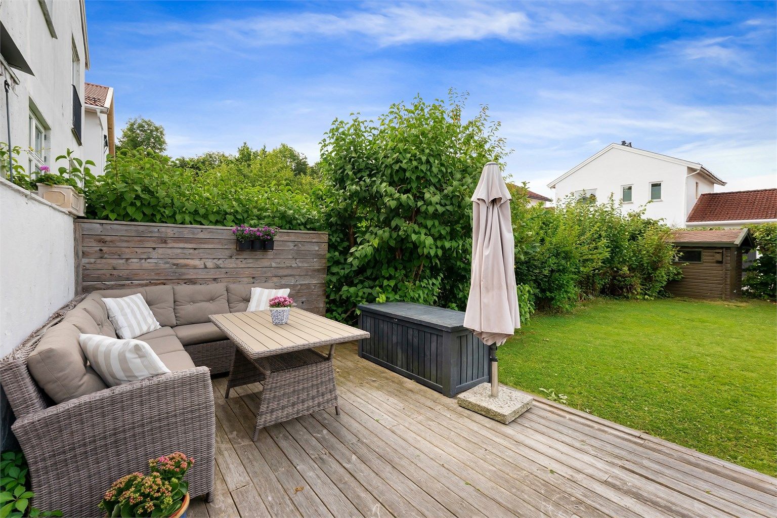 Romslig markterrasse på 22 m² i trekonstruksjon, med trapp fra verandaen.