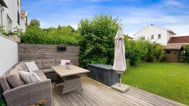 Romslig markterrasse på 22 m² i trekonstruksjon, med trapp fra verandaen.