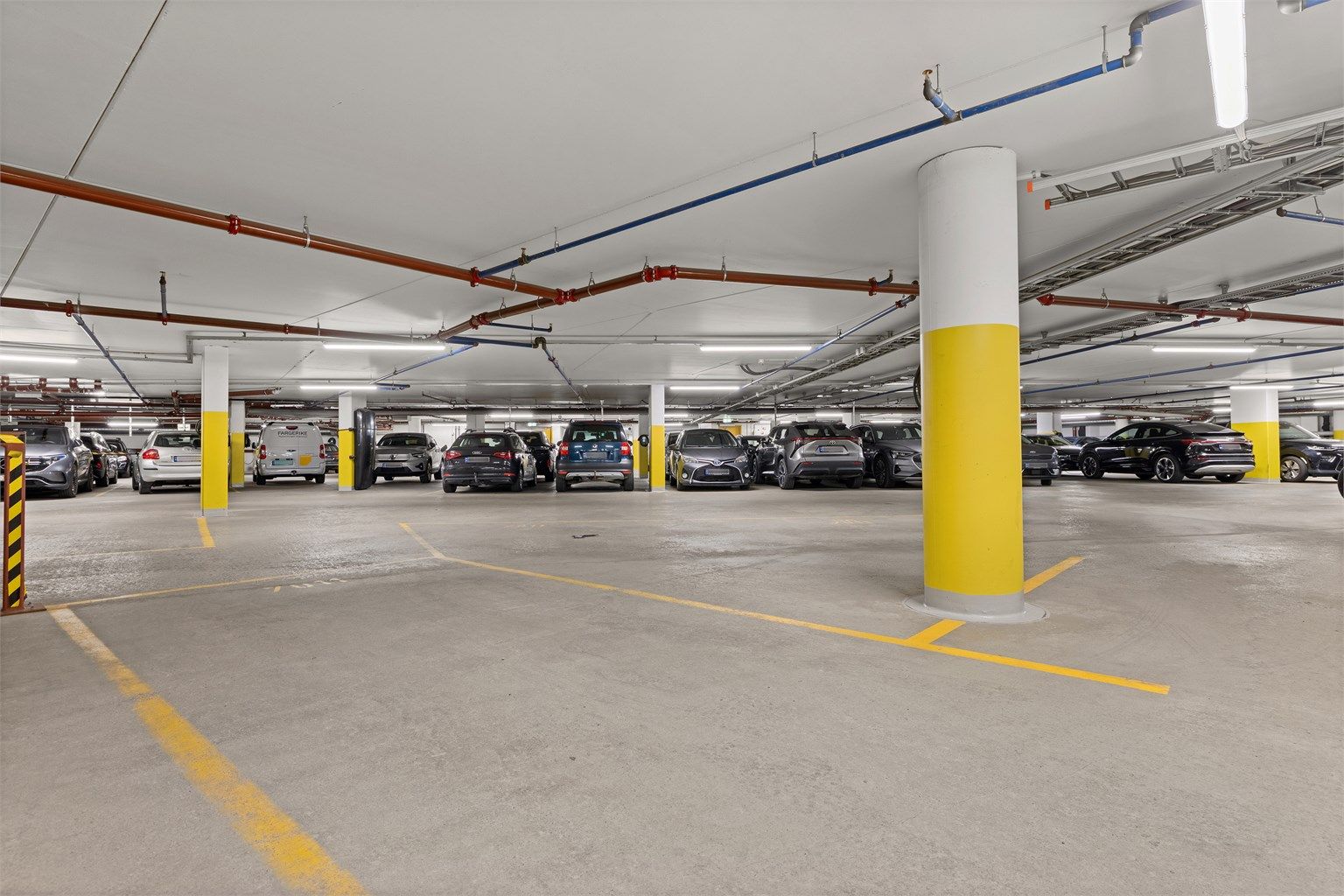 De to parkeringsplassene er ved siden av hverandre og deler på 1 elbillader - Den ene plassen er en ekstra stor p-plass markert med HC
