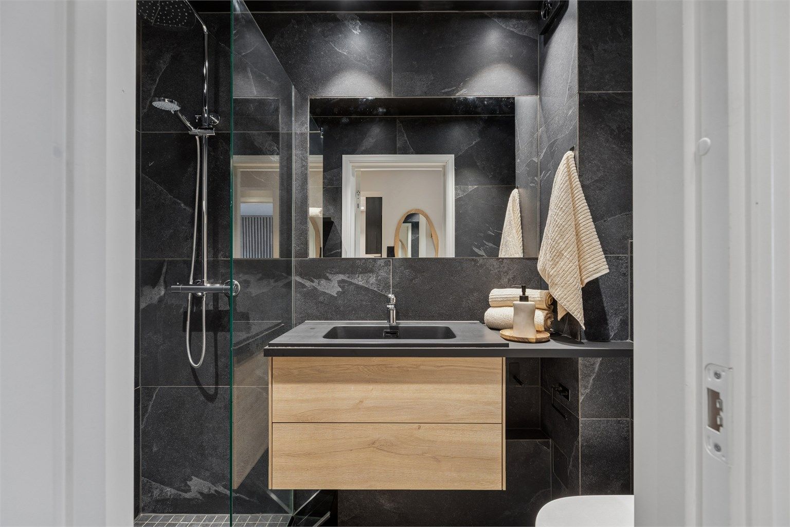 Badet har flislagte overflater, gulvvarme og innredning fra HTH.