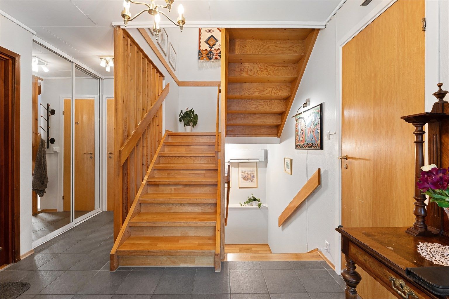 Inngangspartiet har flislagt gulv med gulvvarme og en romslig skyvedørsgarderobe.