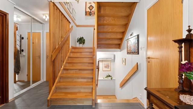 Inngangspartiet har flislagt gulv med gulvvarme og en romslig skyvedørsgarderobe.