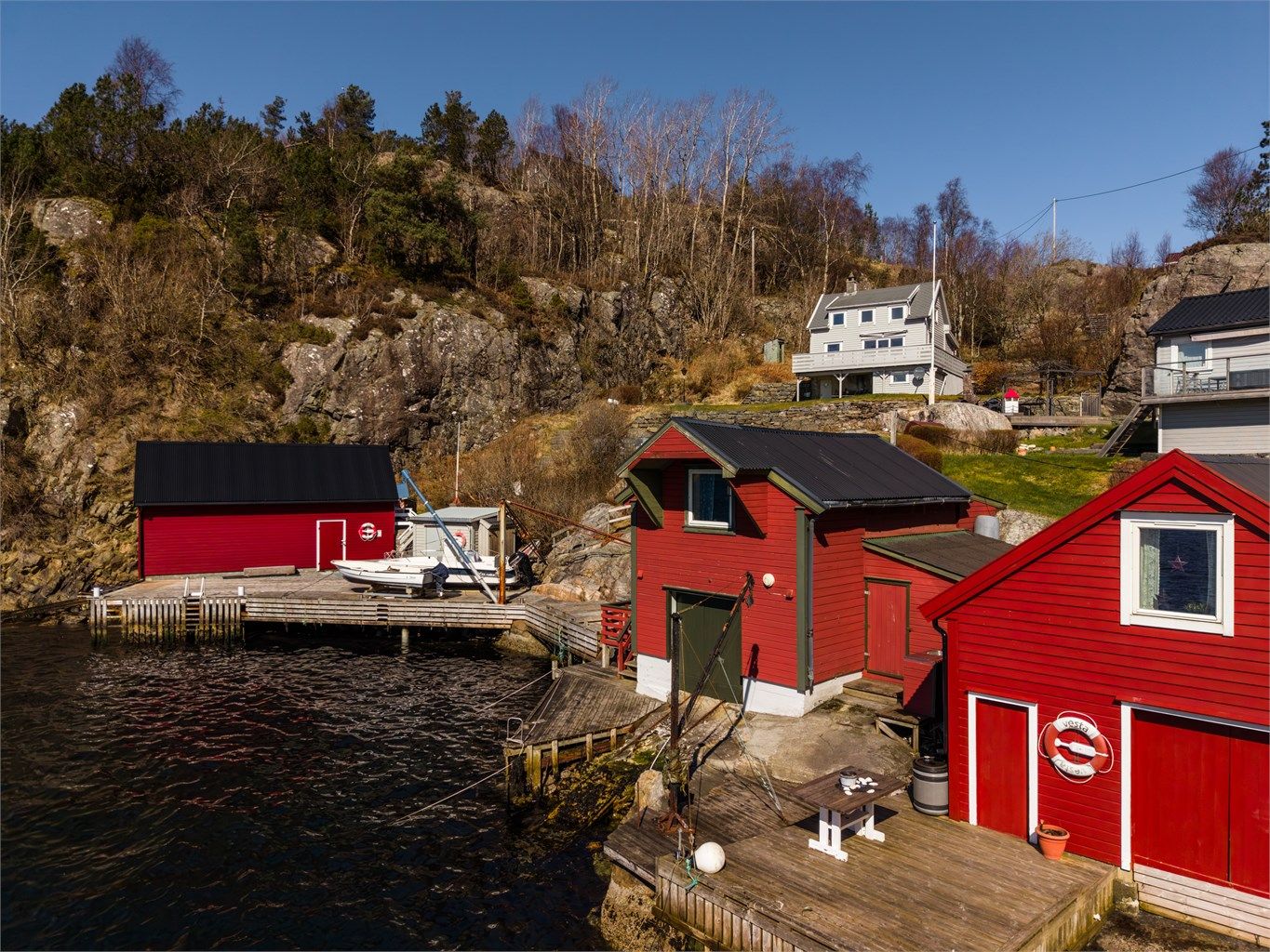 Uteområdet består av en kai og terrasse/ treplatting, som gir en funksjonell base for båtliv og aktiviteter ved vannet.
