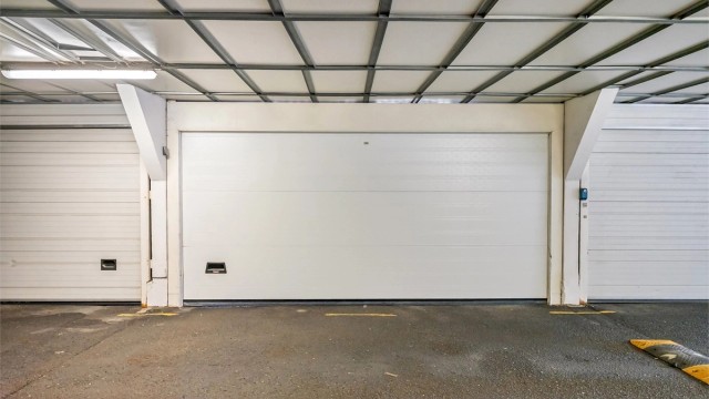 Garasjeplassen er lukket med automatisk leddport, og er plassert like ved døren til blokken. Porten er dobbel og deles med naboen