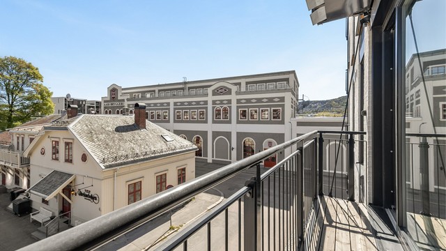Balkongen har gulv av terrassebord, utebelysning og utvendig stikkontakt.