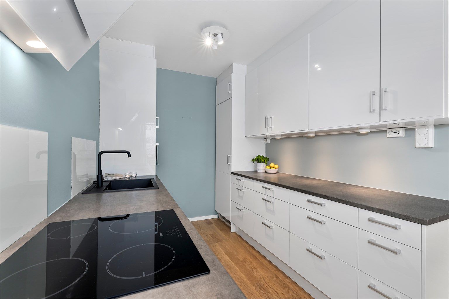 Lys og moderne kjøkken fra 2016 med slette fronter og integrerte hvitevarer.