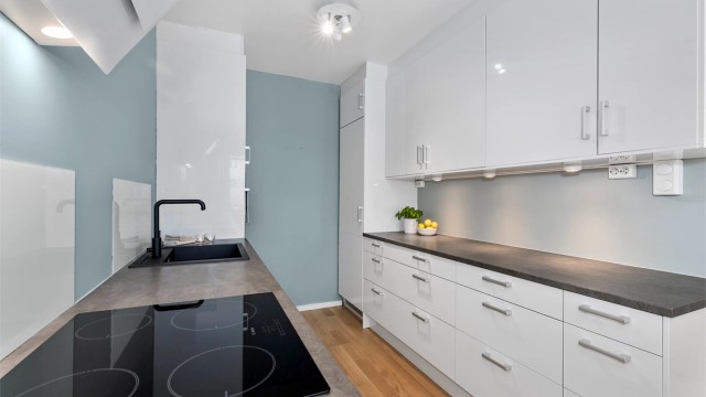 Lys og moderne kjøkken fra 2016 med slette fronter og integrerte hvitevarer.