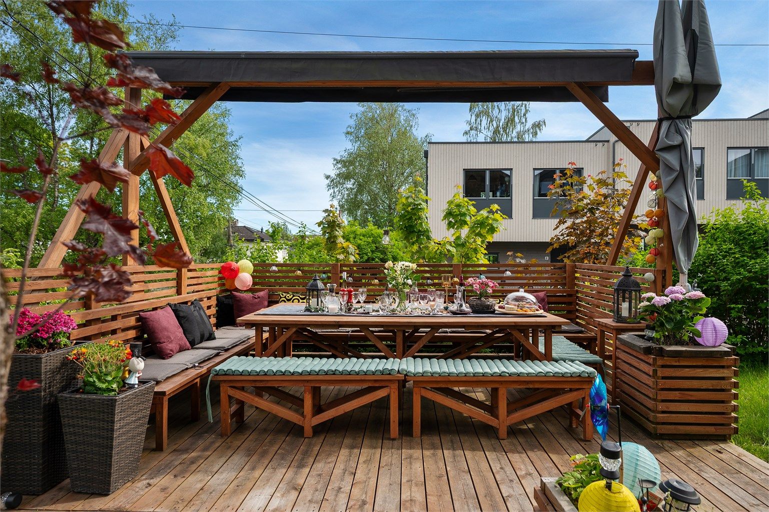 Flott, usjenert uteplass med pergola med to markiser. 