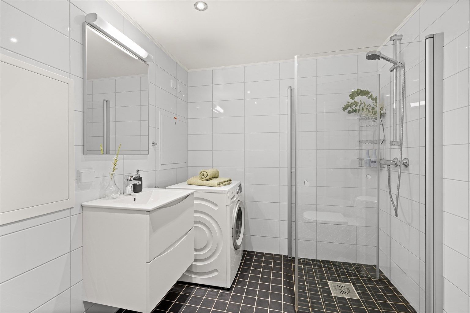 Badet består av flislagt gulv med gulvvarme og flislagte vegger.