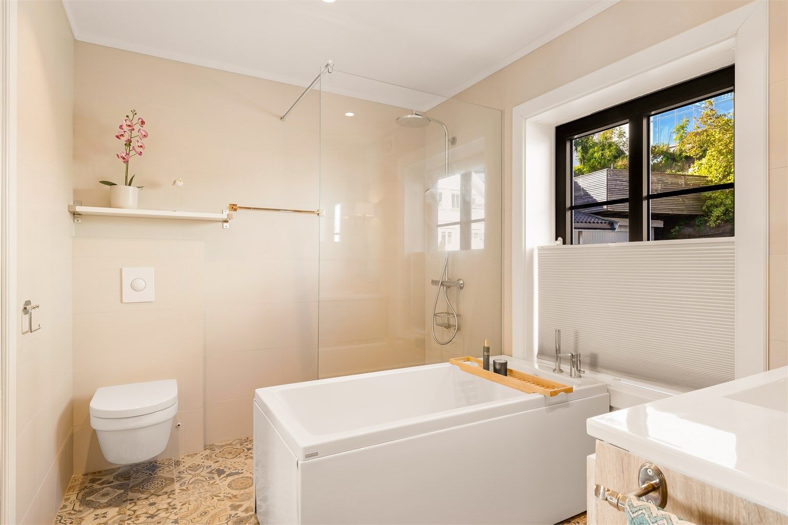 Badet er en drøm med stor dusjnisje, badekar, servant med speil over og vegghengt wc.