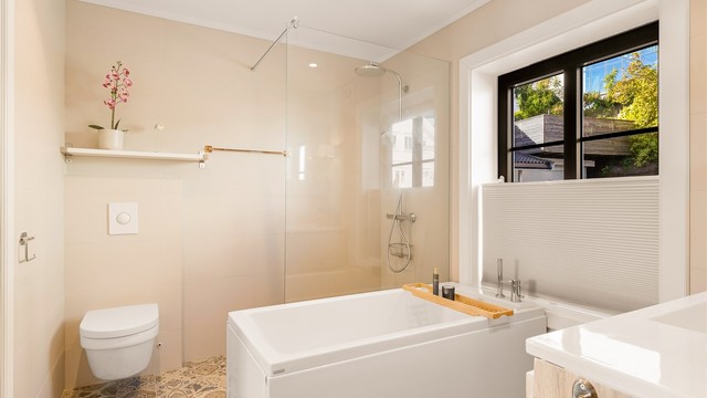Badet er en drøm med stor dusjnisje, badekar, servant med speil over og vegghengt wc.
