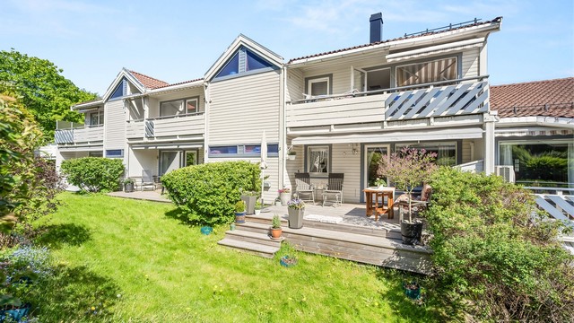 Beliggenheten på bakkeplan gir enkel adkomst til de grønne fellesarealene, mens beplantningen rundt uteplassen bidrar til en lun og skjermet atmosfære.