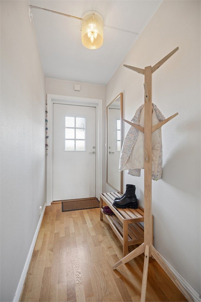Praktisk entré med stilren eikeparkett og rikelig plass til yttertøy.