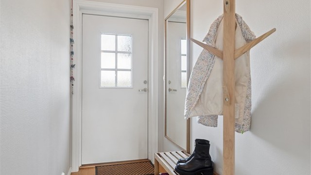 Praktisk entré med stilren eikeparkett og rikelig plass til yttertøy.