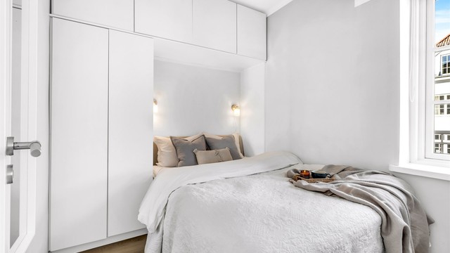 Lyst soverom med plass til dobbeltseng. Det er etablert en plassbygget garderobeløsning på veggen, som gir gode oppbevaringsmuligheter.