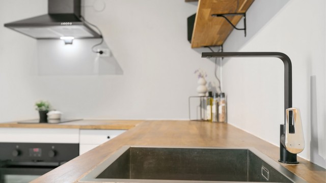 Moderne, sort blandebatteri og underlimt vask.